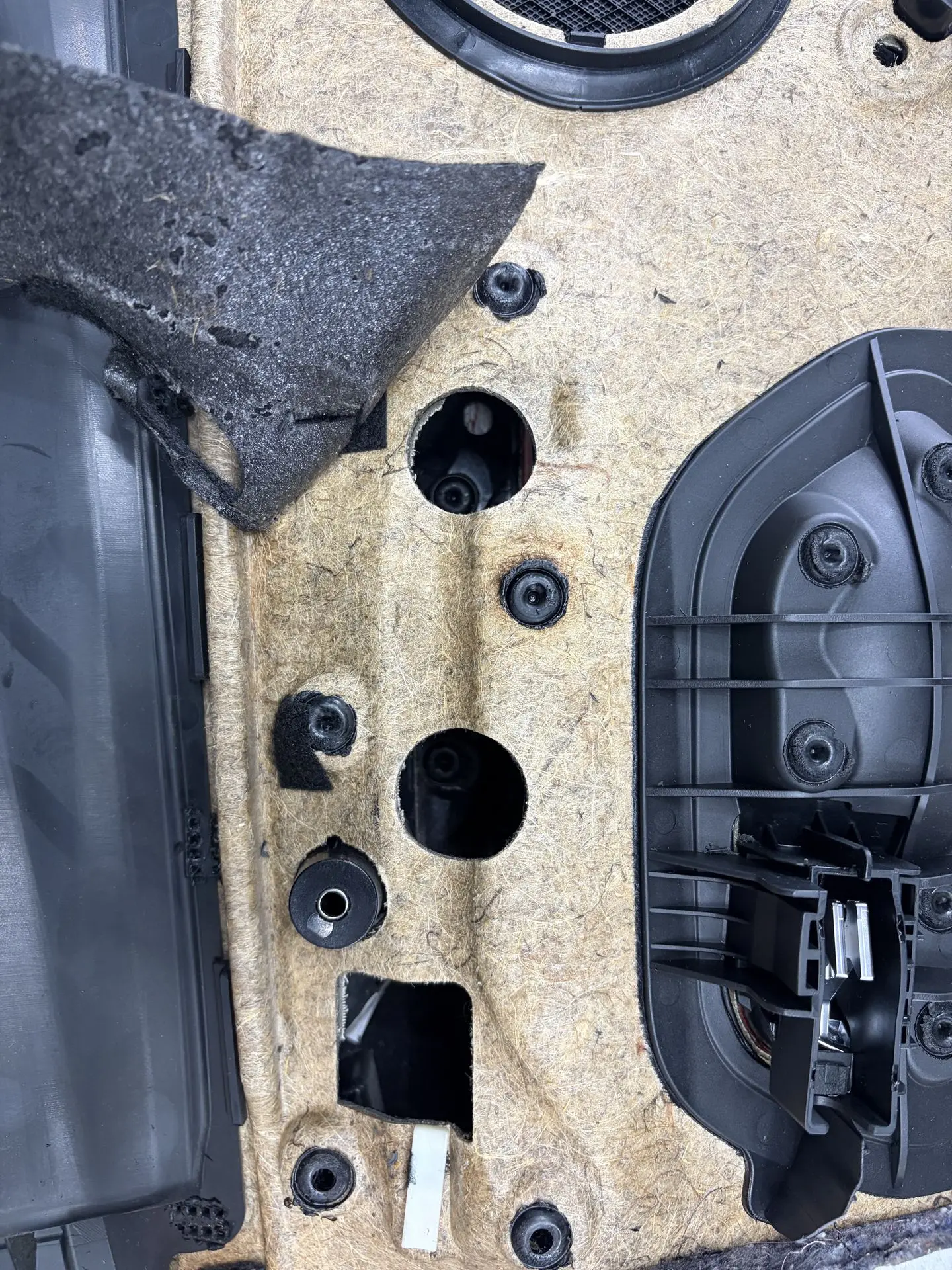 Melted plastic mounting points on the back of a BMW door panel