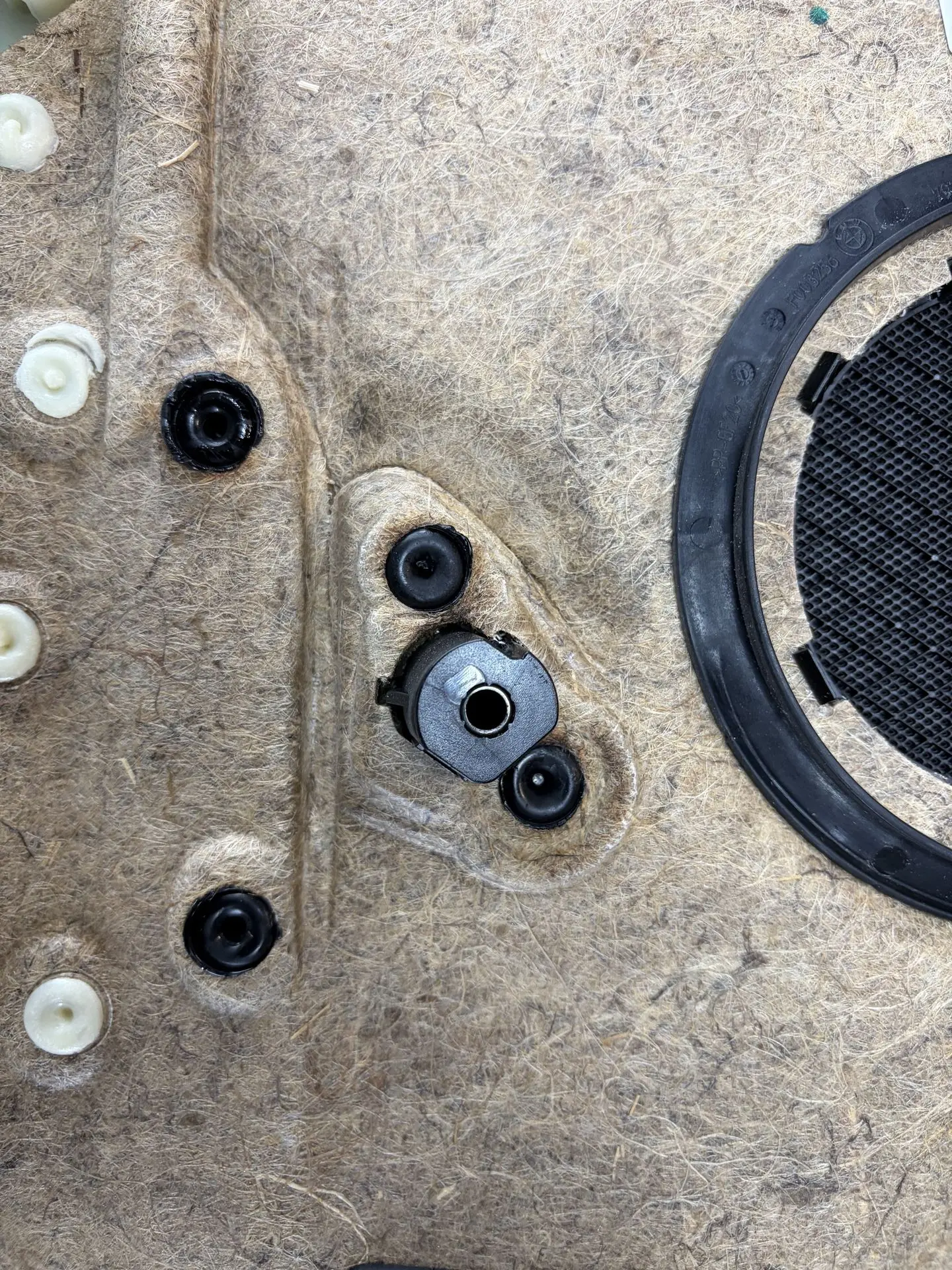 Melted plastic mounting points on the back of a BMW door panel